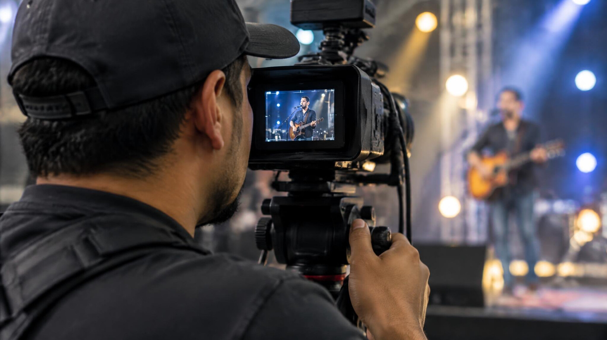Camera operator framing a performer on stage